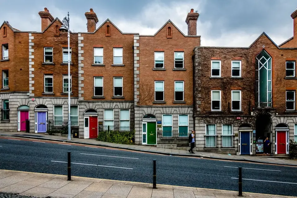 Fila de casas georgianas de ladrillo con puertas de colores en una calle de Dublín
