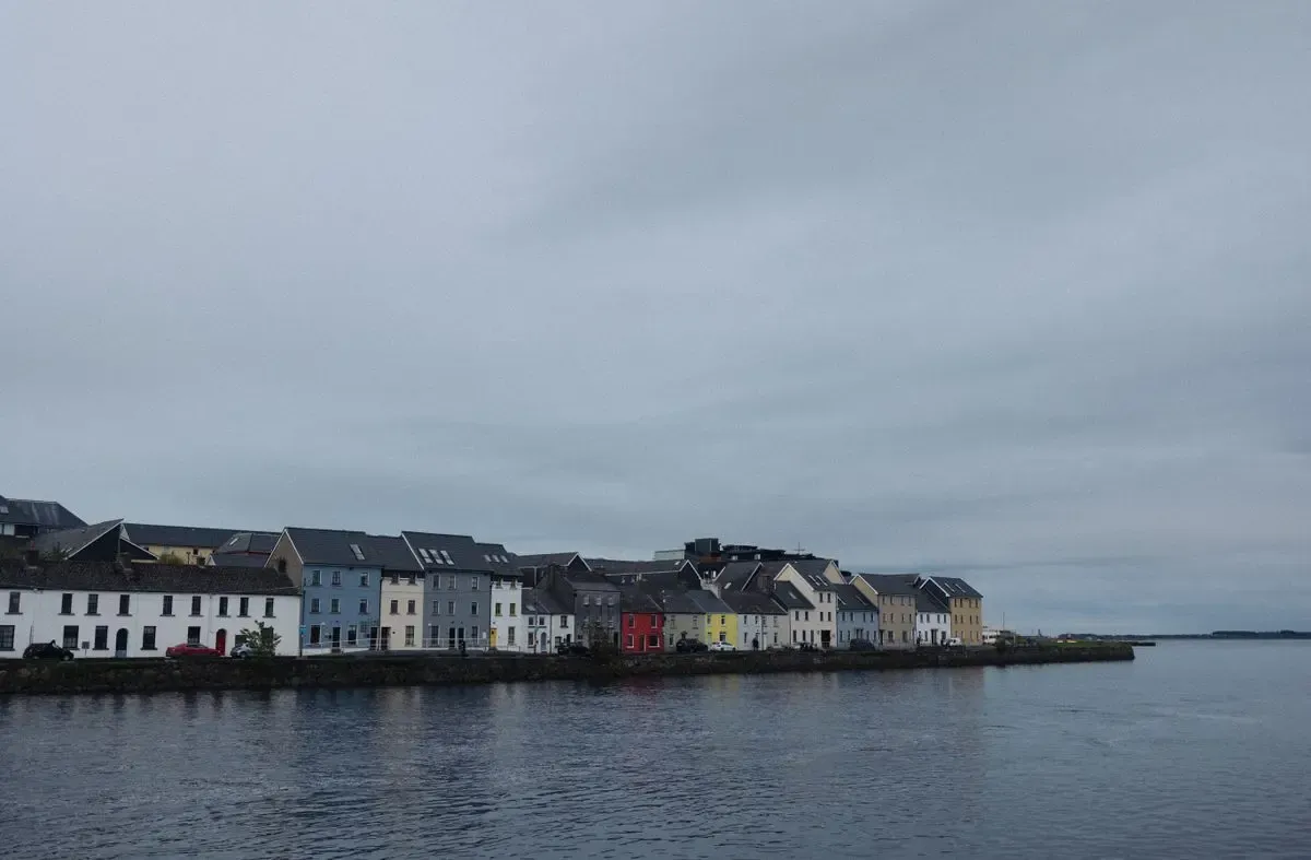 Casas de colores de The Long Walk junto al agua en Galway, bajo un cielo nublado